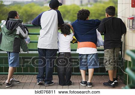 Stock Image - Boys leaning against railing. Fotosearch