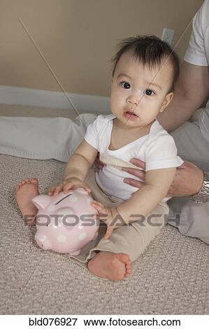 Chinese father and baby with piggy bank View Large Photo Image Stock Photo - Chinese father and baby with piggy bank. Fotosearch