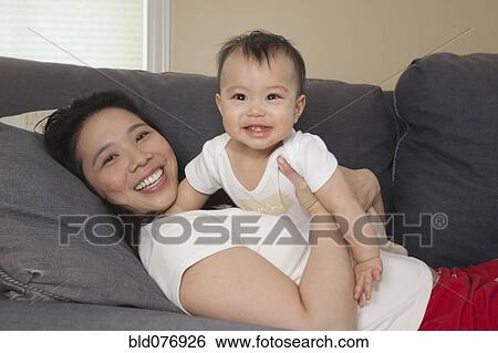 Chinese mother and baby on sofa View Large Photo Image Stock Photograph - Chinese mother and baby on sofa. Fotosearch