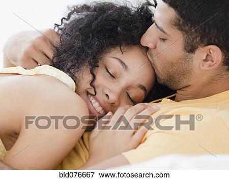 Couple cuddling on bed View Large Photo Image Stock Photo - Couple cuddling on bed. Fotosearch