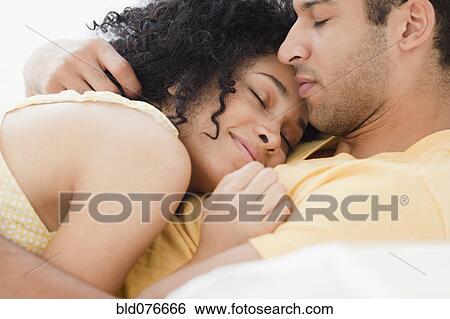 Stock Photograph - Couple cuddling on bed. Fotosearch