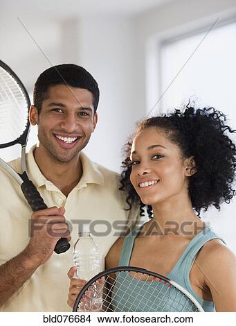 Picture - Couple holding tennis rackets. Fotosearch