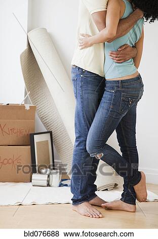 Couple hugging in living room View Large Photo Image Stock Photo - Couple hugging in living room. Fotosearch