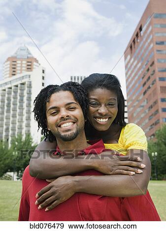 Stock Photo - Couple hugging in urban park. Fotosearch