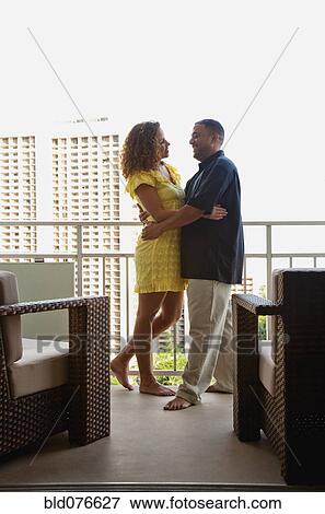 Stock Photo - Couple hugging on urban balcony. Fotosearch