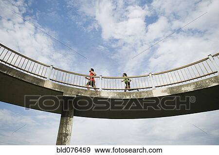Stock Photo - Couple running on bridge. Fotosearch