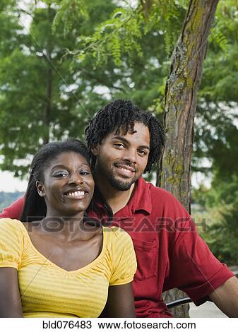 Stock Image - Couple sitting in park. Fotosearch