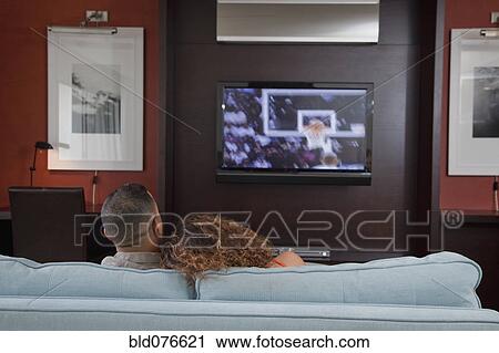 Couple watching basketball game on television in living room View Large Photo Image Stock Image - Couple watching basketball game on television in living room. Fotosearch
