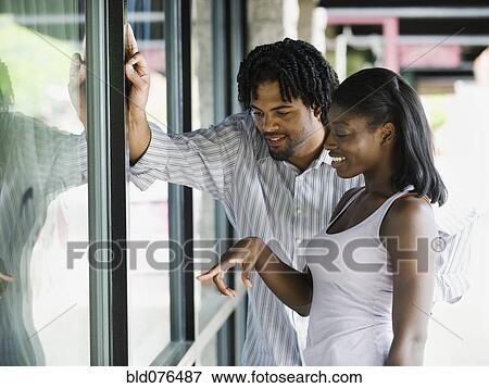 Couple window shopping View Large Photo Image Stock Photo - Couple window shopping. Fotosearch