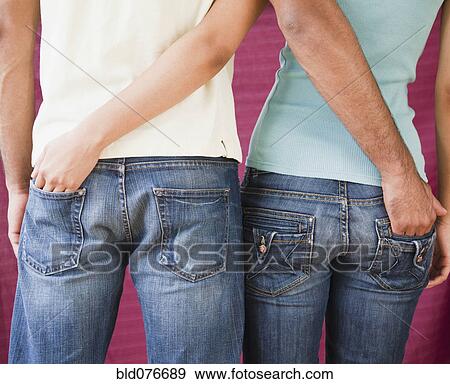 Stock Photo - Couple with hands in each other's rear jeans pockets. Fotosearch