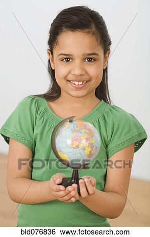 Hispanic girl holding small globe View Large Photo Image Stock Photograph - Hispanic girl holding small globe. Fotosearch
