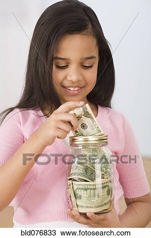 Hispanic girl putting money in jar View Large Photo Image Stock Image - Hispanic girl putting money in jar. Fotosearch