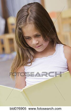 Stock Photography - Hispanic girl reading book. Fotosearch