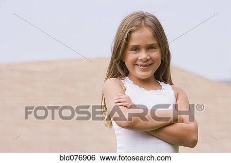 Stock Photograph - Hispanic girl smiling with arms crossed. Fotosearch