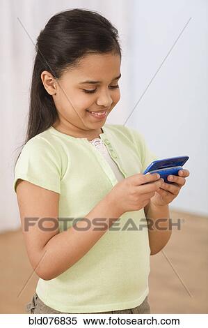 Hispanic girl using cell phone View Large Photo Image Stock Photography - Hispanic girl using cell phone. Fotosearch