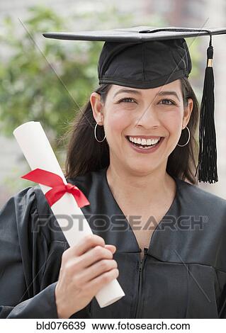 Stock Photo - Hispanic graduate holding diploma. Fotosearch