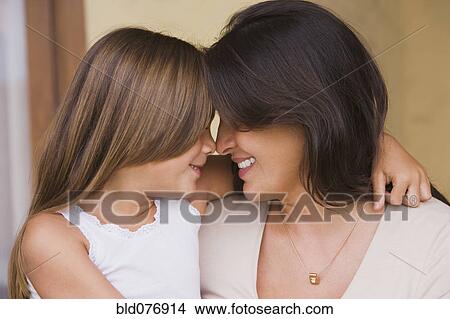 Picture - Hispanic mother and daughter hugging. Fotosearch