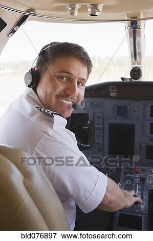 Stock Photo - Hispanic pilot in cockpit. Fotosearch