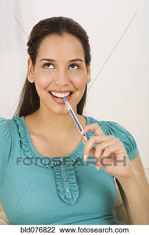 Hispanic woman biting end of pen View Large Photo Image Stock Image - Hispanic woman biting end of pen. Fotosearch