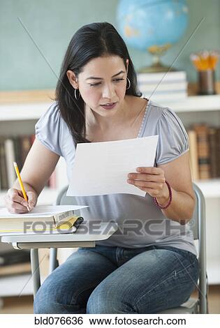 Hispanic woman doing homework in classroom View Large Photo Image Stock Photograph - Hispanic woman doing homework in classroom. Fotosearch