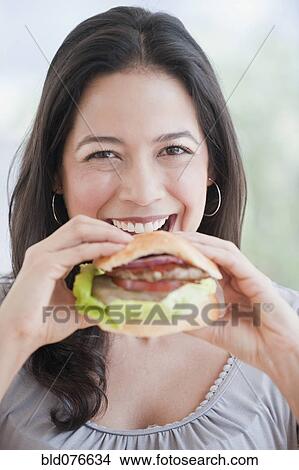 Hispanic woman eating hamburger View Large Photo Image Picture - Hispanic woman eating hamburger. Fotosearch