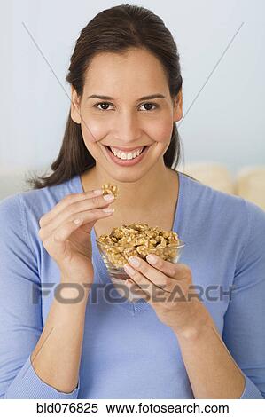 Hispanic woman eating walnuts View Large Photo Image Stock Photography - Hispanic woman eating walnuts. Fotosearch