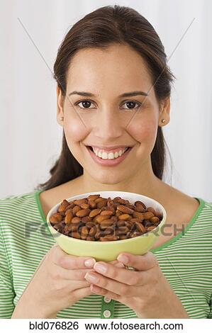 Hispanic woman holding bowl of almonds View Large Photo Image Stock Photograph - Hispanic woman holding bowl of almonds. Fotosearch