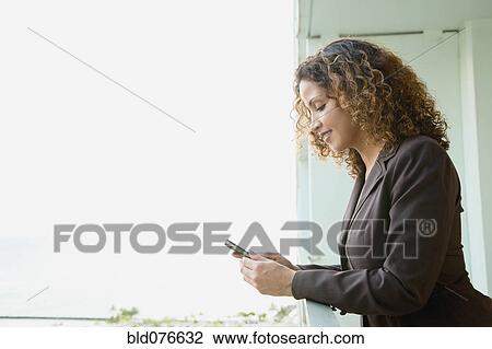 Hispanic woman text messaging on balcony View Large Photo Image Stock Image - Hispanic woman text messaging on balcony. Fotosearch