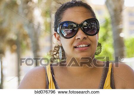Hispanic woman wearing sunglasses View Large Photo Image Stock Photograph - Hispanic woman wearing sunglasses. Fotosearch