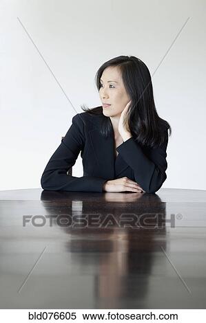 Japanese businesswoman looking pensive at table View Large Photo Image Stock Photography - Japanese businesswoman looking pensive at table. Fotosearch