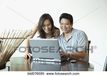 Japanese couple using laptop at table View Large Photo Image Stock Photography - Japanese couple using laptop at table. Fotosearch