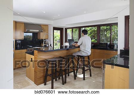 Japanese man using laptop at kitchen counter View Large Photo Image Stock Image - Japanese man using laptop at kitchen counter. Fotosearch