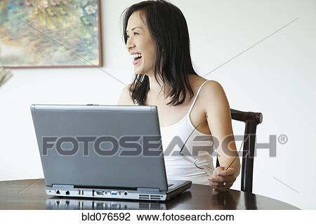 Japanese woman using laptop at table View Large Photo Image Stock Image - Japanese woman using laptop at table. Fotosearch