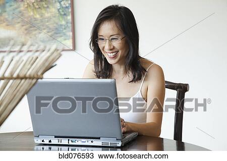 Japanese woman using laptop at table View Large Photo Image Stock Image - Japanese woman using laptop at table. Fotosearch