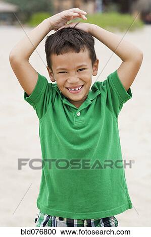 Mixed race boy smiling on beach View Large Photo Image Stock Image - Mixed race boy smiling on beach. Fotosearch