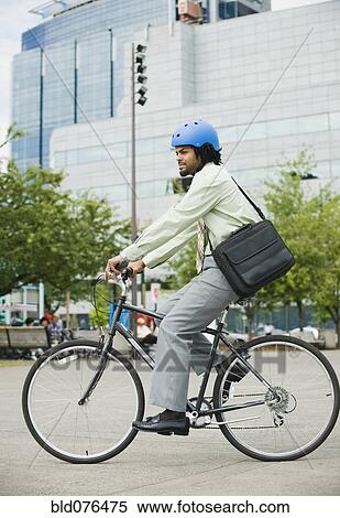 Stock Photography - Mixed race man riding bicycle in city. Fotosearch