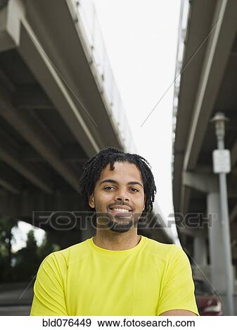 Mixed race man smiling under freeway overpass View Large Photo Image Stock Photo - Mixed race man smiling under freeway overpass. Fotosearch