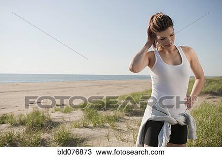 Stock Image - Mixed race woman in sportswear on beach. Fotosearch