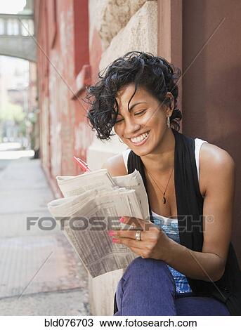 Mixed race woman reading classified ads on urban street View Large Photo Image Stock Image - Mixed race woman reading classified ads on urban street. Fotosearch