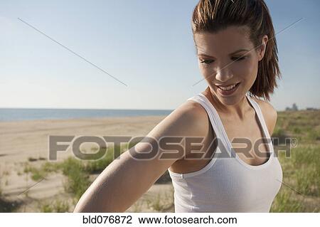 Stock Image - Mixed race woman smiling on beach. Fotosearch