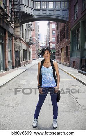 Mixed race woman standing on urban street View Large Photo Image Stock Photo - Mixed race woman standing on urban street. Fotosearch