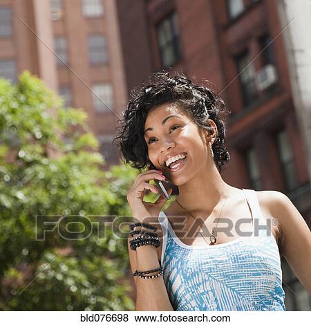 Mixed race woman talking on cell phone View Large Photo Image Stock Photo - Mixed race woman talking on cell phone. Fotosearch