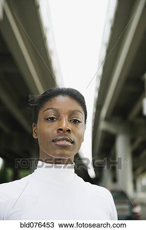 Serious African woman standing under freeway overpass View Large Photo Image Stock Image - Serious African woman standing under freeway overpass. Fotosearch