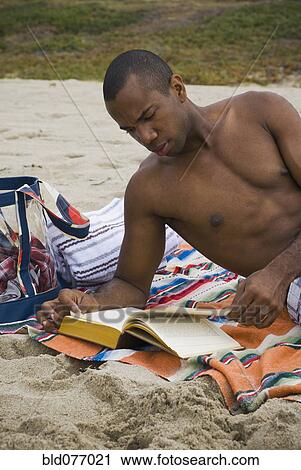 African man reading book on beach View Large Photo Image Stock Image - African man reading book on beach. Fotosearch