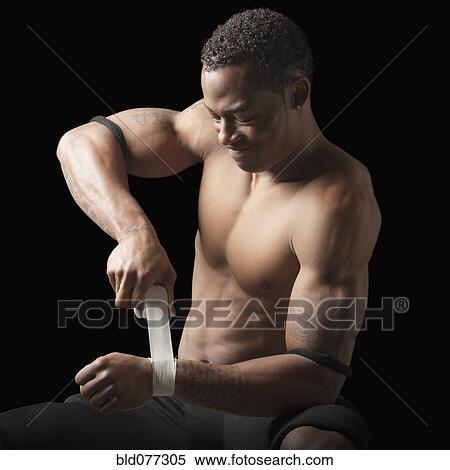 Bare chested football player taping wrist View Large Photo Image Stock Photography - Bare chested football player taping wrist. Fotosearch