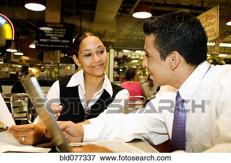 Stock Photo - Business people working over lunch. Fotosearch