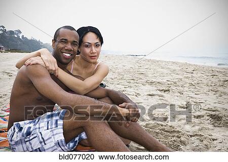 Stock Image - Couple hugging on beach. Fotosearch