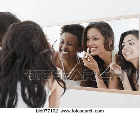 Friends applying makeup in mirror View Large Photo Image Stock Image - Friends applying makeup in mirror. Fotosearch