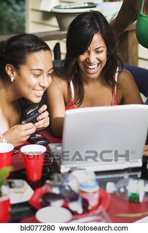 Friends looking at laptop View Large Photo Image Stock Image - Friends looking at laptop. Fotosearch