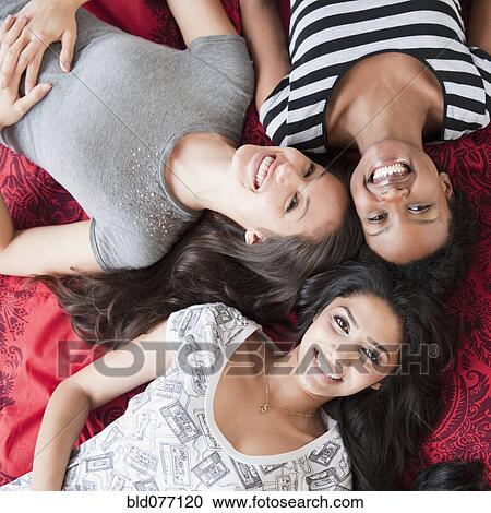 Friends relaxing on floor together View Large Photo Image Stock Image - Friends relaxing on floor together. Fotosearch